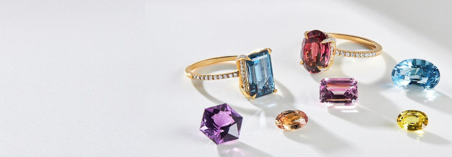 Loose gemstones and engagement rings displayed together by SAMA