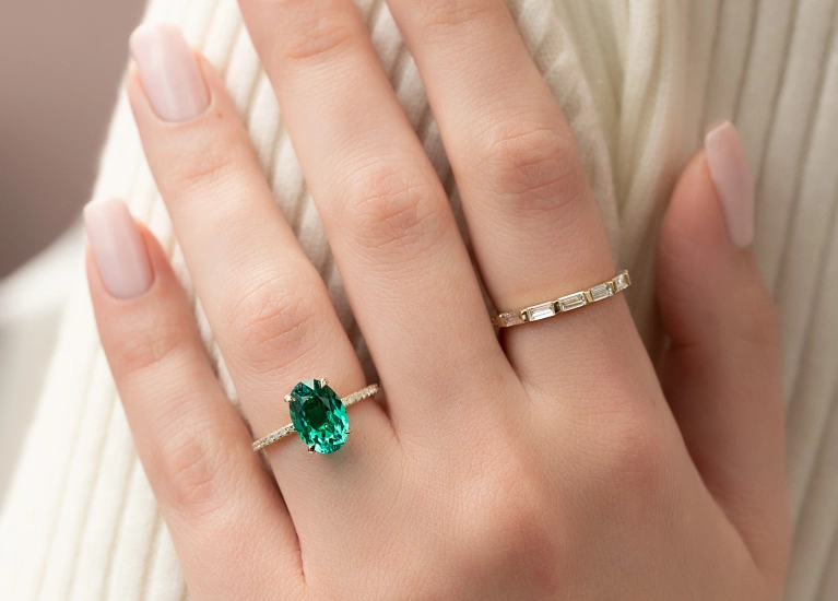 Emerald oval solitaire engagement ring styled for holiday gifting