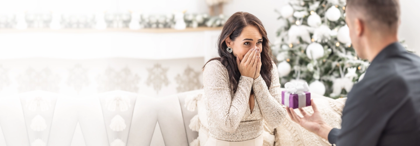 Close-up of a diamond engagement ring and wedding band with soft golden bokeh lights in the background