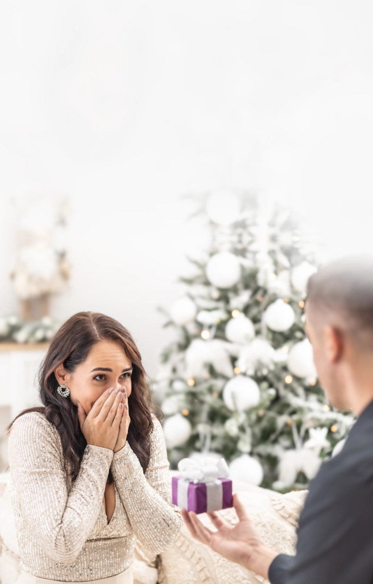 Close-up of a diamond engagement ring and wedding band with soft golden bokeh lights in the background